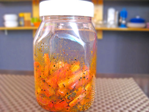 Adding of mustard oil and carrots in a jar